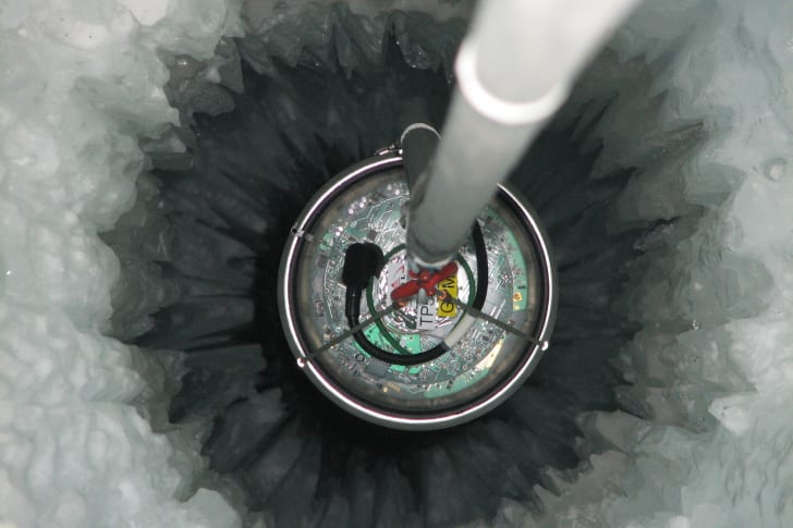 A sensor called a Digital Optical Module is lowered one mile into Antarctica's ice under the IceCube neutrino detector.